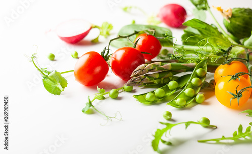 Fresh green peas pods, radish, green asparagus, tomatoes