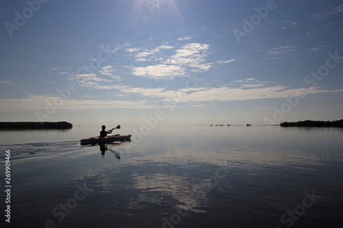 Kayaker enjoying a very calm early morning paddle on Biscayne Bay in Biscayne National Park, Florida