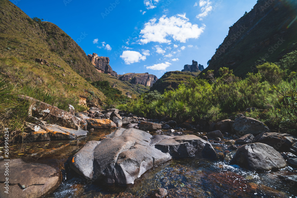 Obraz premium Scenic river and mountains while hiking, Drakensberg, South Africa