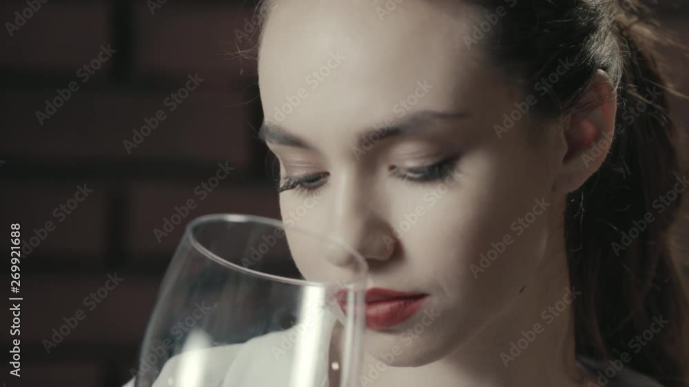 Portrait pretty woman sniffing wineglass and drinking red wine close up Portrait pretty woman sniffing wineglass and drinking red wine close up