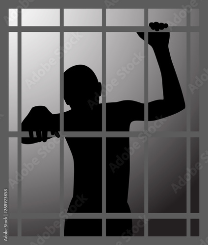 Man in dark dungeon or prison behind bars