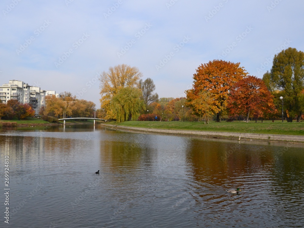 Pond and colorful trees in the park on a warm autumn day. Kepa Potocka, Warsaw, Poland