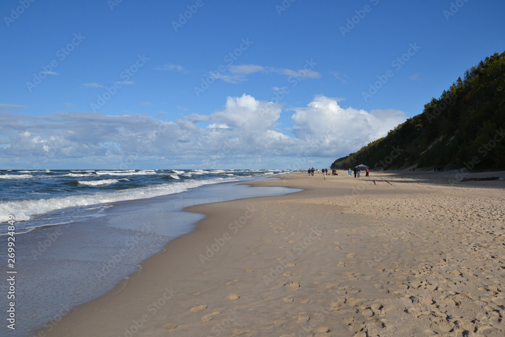 Beautiful sandy beach and rough sea on a cool autumn day. Baltic Sea coast, Poland, Europe