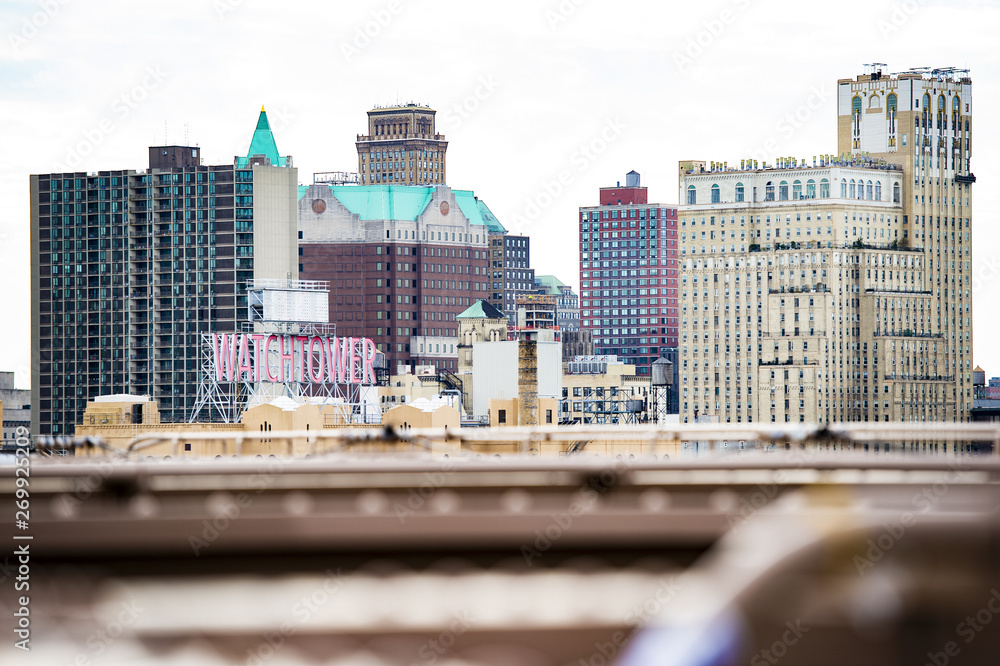 Manhattan skyline with the Watchtover sign seen from the Brooklyn Bridge. The Watchtover sign was originally installed more than 70 years ago. Manhattan, New York City, USA.