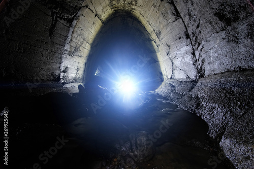 Underground river flowing through large oviform underground sewer tunnel