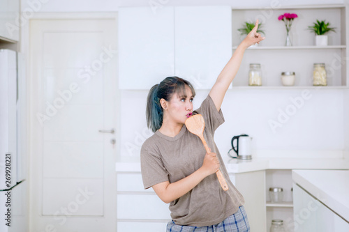 Attractive woman singing in the kitchen