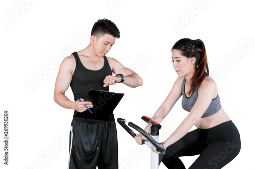 Male trainer timing his client during using a bicycle