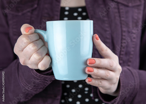 A woman holding blue mug
