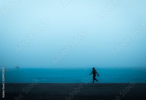 person jogging alone at blue hour by lake