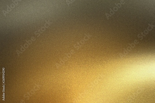 Light shining on golden metal foil in dark room, abstract texture background