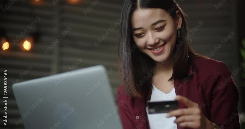 Young asian girl sitting on her bed with laptop, having online shopping, keying in credit card. Panasian student making purchase via internet - closeup 4k Young asian girl sitting on her bed with laptop, having online shopping, keying in credit card. Panasian student making purchase via internet - closeup 4k