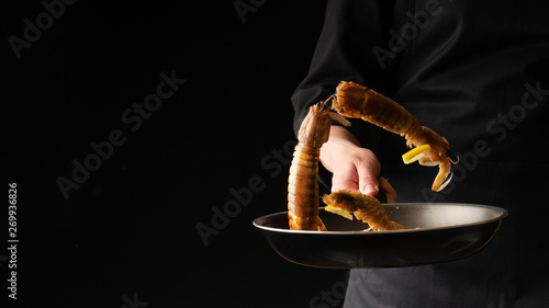 Chef prepares sea food, mantis shrimp, East Asian cuisine, dilikates, on a black background, horizontal photo, banner photo