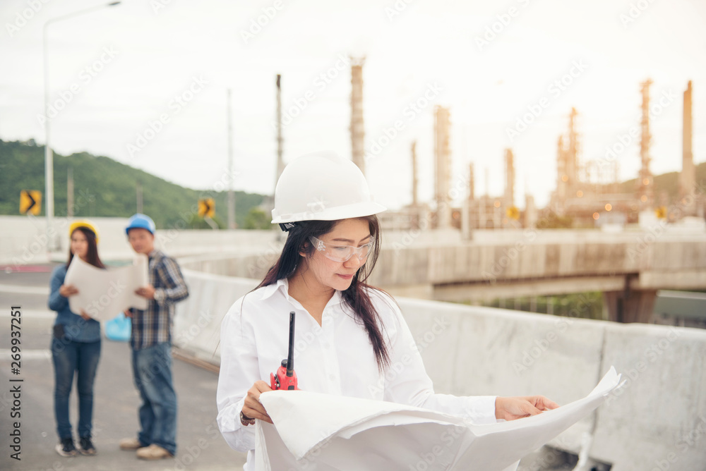 Smart woman engineer holding white hard hat on hand and look at refinery industry plant at industry factory center area. Engineering Concept Smart woman engineer holding white hard hat on hand and look at refinery industry plant at industry factory center area. Engineering Concept