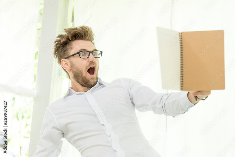 Fototapeta premium Caucasian man holding text book study hard surprise in content. education concept