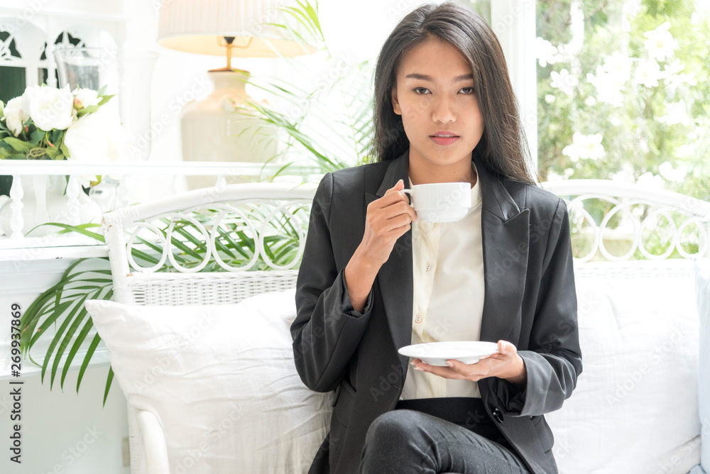 Working beautiful woman sitting on black and white sofa using technology with smart tablet modern lifestyle. searching internet and online shopping. Business Woman Concept Working beautiful woman sitting on black and white sofa using technology with smart tablet modern lifestyle. searching internet and online shopping. Business Woman Concept