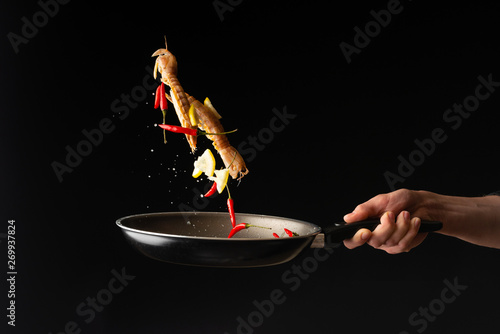 Chef prepares sea food, mantis shrimp with lemon and hot pepper, East Asian cuisine, dilikates, on a black background, horizontal photo, close-up