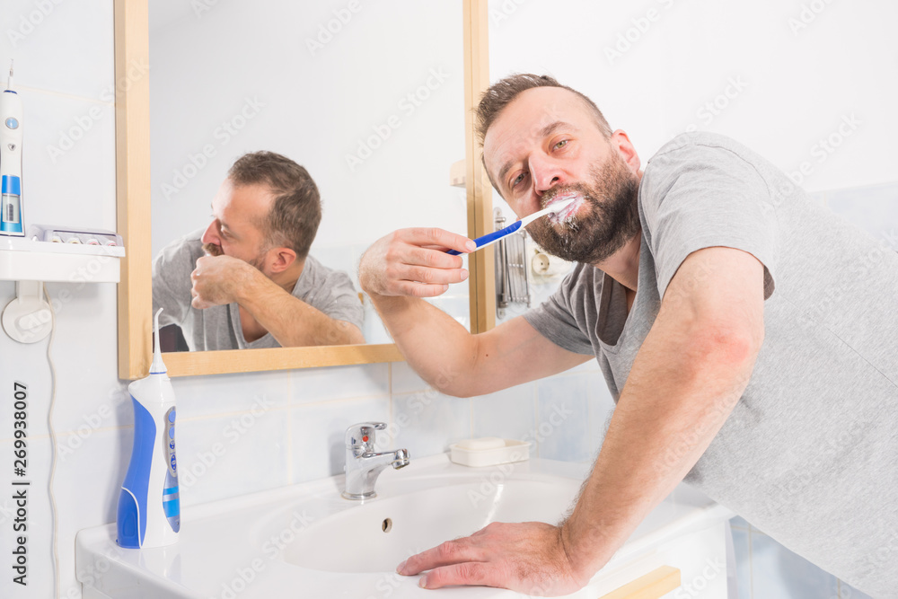 Man brushing his teeth in bathroom Man brushing his teeth in bathroom