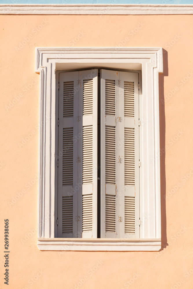 Old window shutters on orange home