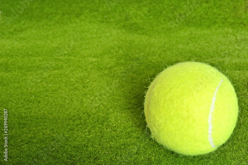 yellow tennis ball on the green grass lawn court in corner © andreynov