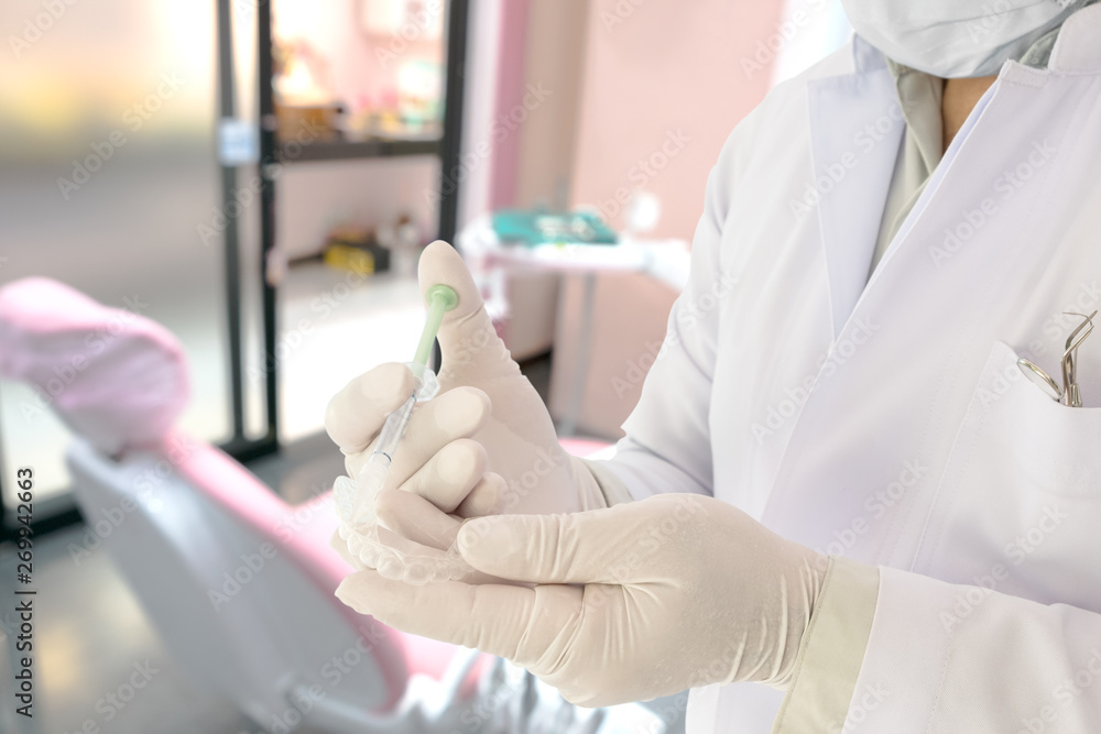 Dentist show dental retainer orthodontic appliance in his hand / in office or clinic. Dentist show dental retainer orthodontic appliance in his hand / in office or clinic.