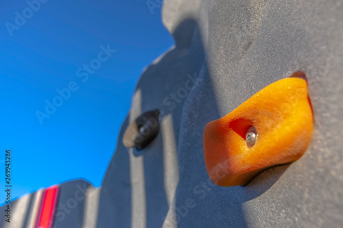 Close up of a climbing wall at a playground with clear blue sky background