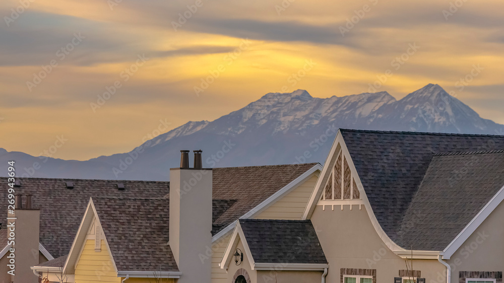 Roofs of houses with a striking mountain capped with snow in the background
