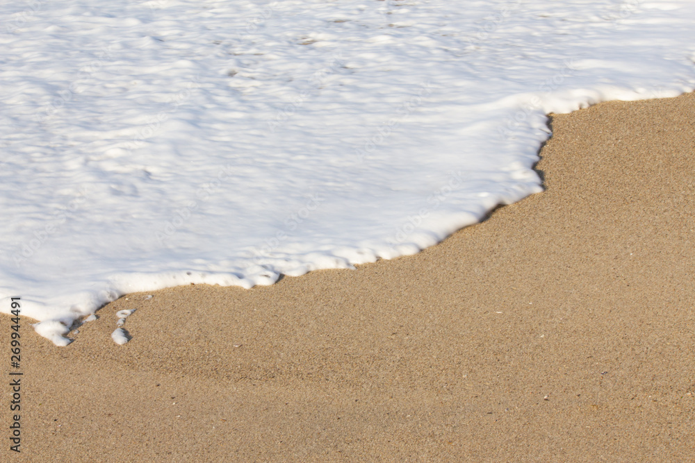 foaming breaking wave and backwash foam on a sandy shoreline foaming breaking wave and backwash foam on a sandy shoreline