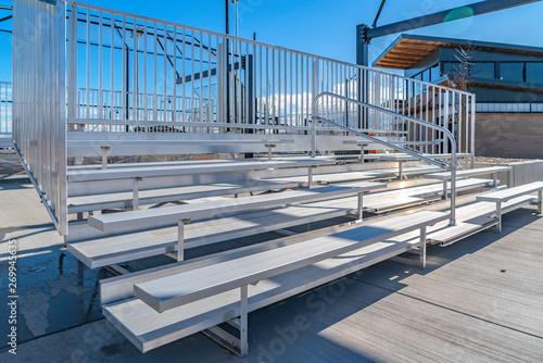 Quadro em tela Bleachers with railings against a building and cloudy blue sky