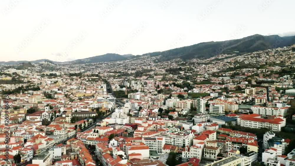 Amazing aerial panoramic view over Funchal, Madeira, in beautiful light. Mountain and green lush landscape in the distance. Amazing aerial panoramic view over Funchal, Madeira, in beautiful light. Mountain and green lush landscape in the distance.