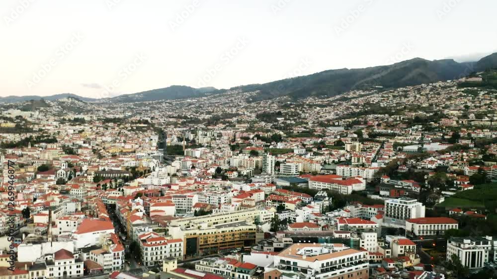 Amazing aerial view over Funchal, Madeira, Rooftops, buildings in beautiful light. Mountains and green lush forest in the distance. Amazing aerial view over Funchal, Madeira, Rooftops, buildings in beautiful light. Mountains and green lush forest in the distance.