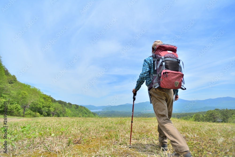 高原のトレッキング・草原を歩く男性