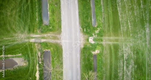 4k aerial drone footage overhead a winding road in the countryside with a black car. photo