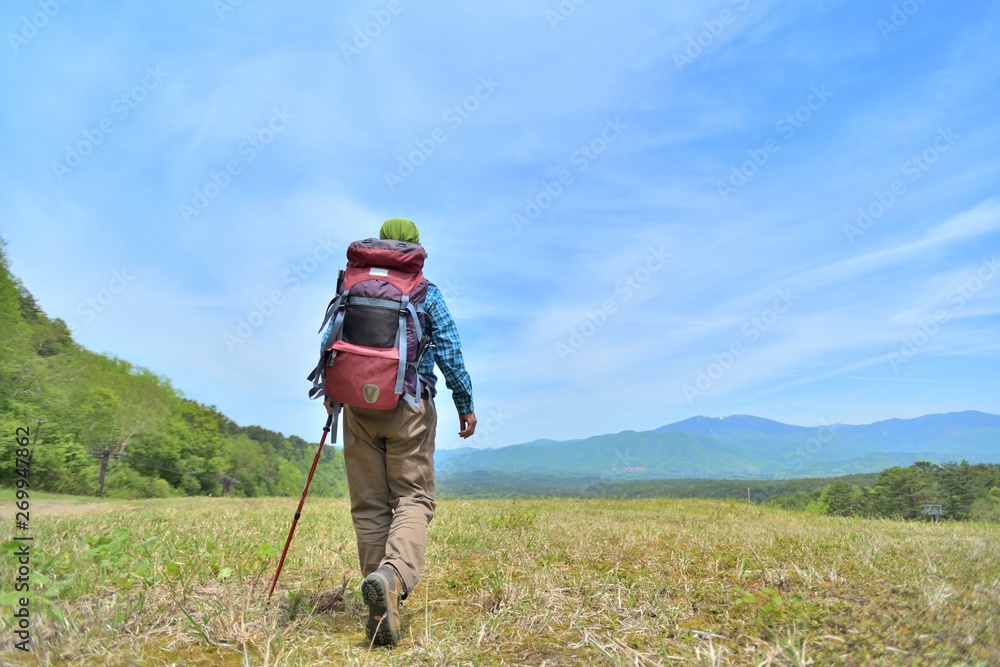 高原のトレッキング・草原を歩く男性