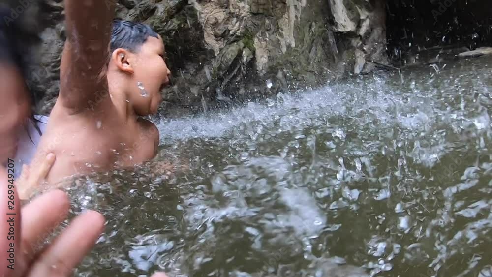 Slow motion action camera of Happy loving family.Father and Mother and daughter relaxing in summer on waterfall.Summer concept Slow motion action camera of Happy loving family.Father and Mother and daughter relaxing in summer on waterfall.Summer concept