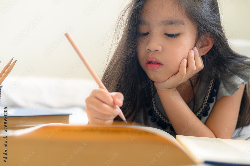 Asian girl writing with pencil and notebook Asian girl writing with pencil and notebook