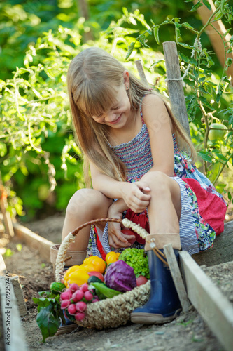 A child with vegetables in the garden. 