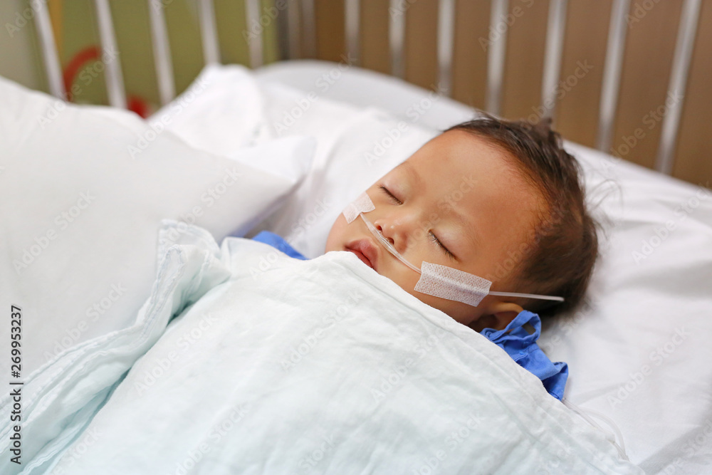 Baby boy age about 1 year old sleeping on patient bed with getting