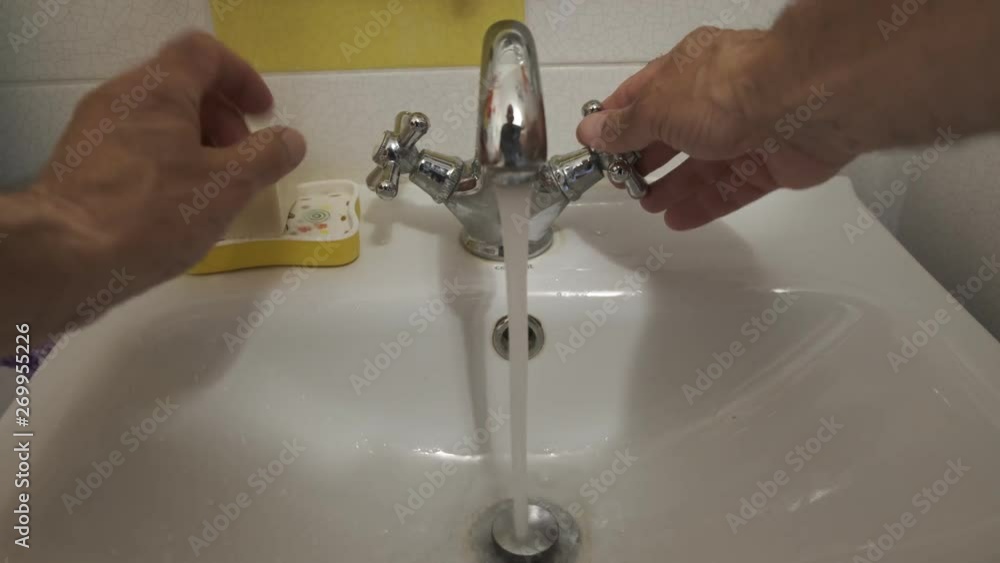 a man washes his hands with water under a faucet with soap a man washes his hands with water under a faucet with soap