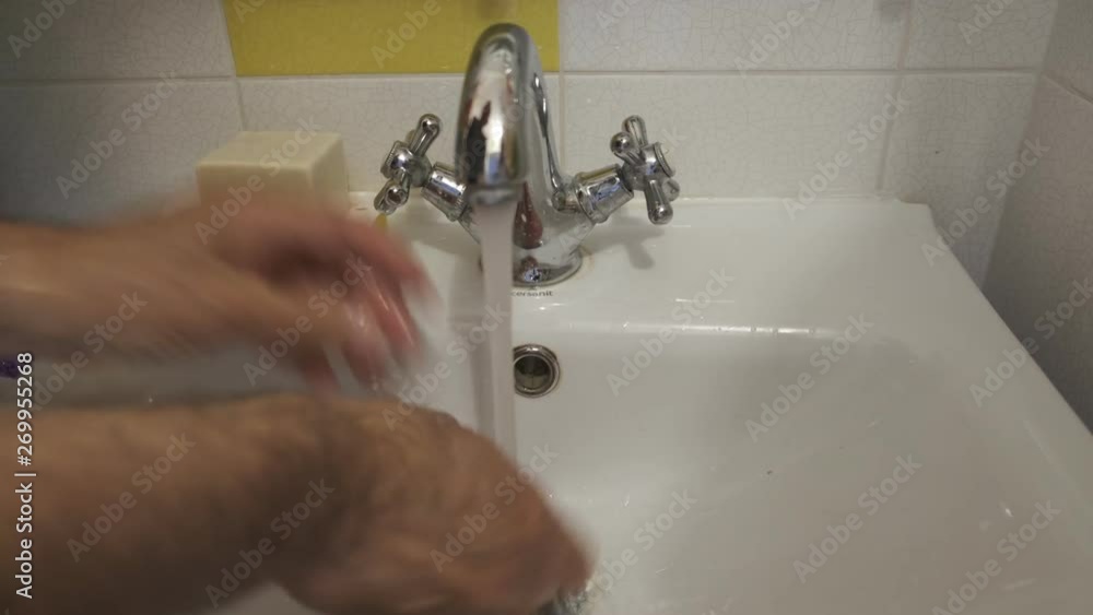 a man washes his hands with water under a faucet with soap a man washes his hands with water under a faucet with soap