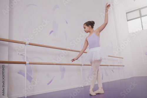 Full lenght shot of a young girl ballerina dancing at ballet school, copy space. Adorable little ballerina enjoying dancing ballet. Education, elegance, childhood concept