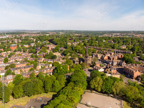 Aerial footage of the Leeds town of Headingley, the footage shows Terrence houses and homes and the town centre in the background with roads and traffic, taken on a beautiful sunny day. photo