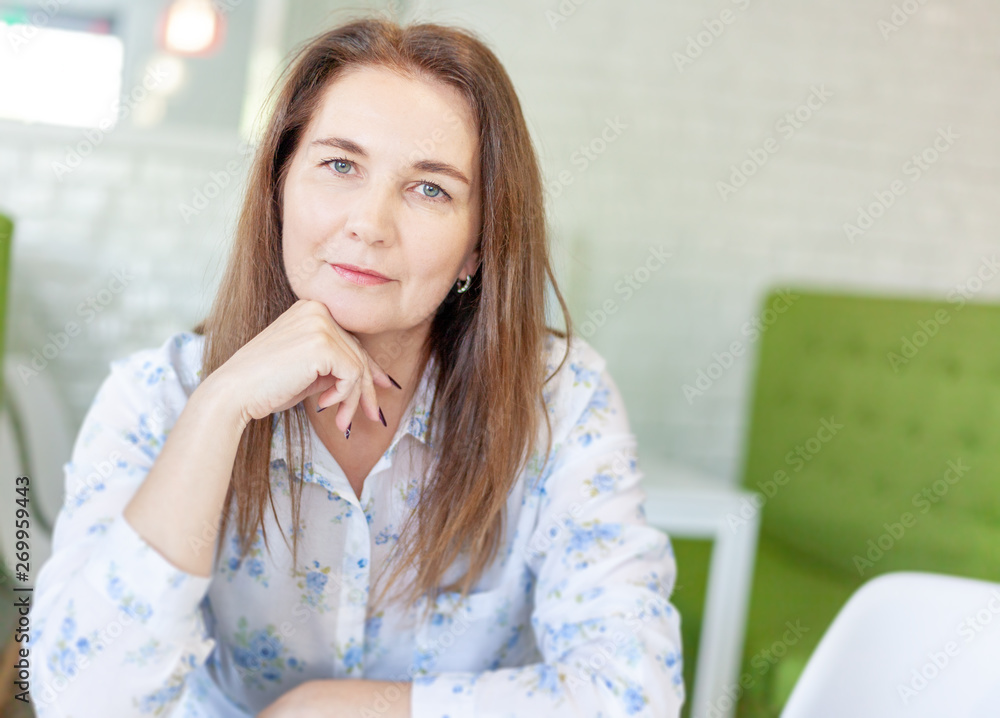 Portrait of attractive middle aged woman, calm smiling face, look into camera Portrait of attractive middle aged woman, calm smiling face, look into camera