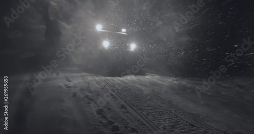 Half-track driving in the night in Jotunheimen in Norway. The half-track has skies in front. Its night and the snow are falling. Filmed on a gimbal in 4k. This is a slow-motion clip. photo