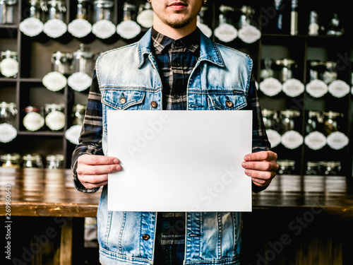a4 paper in hands mockup cafe background