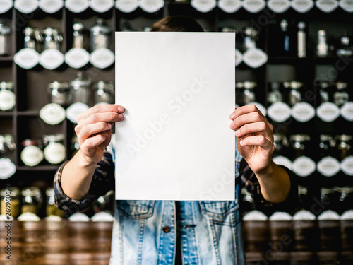 a4 paper in hands mockup cafe background