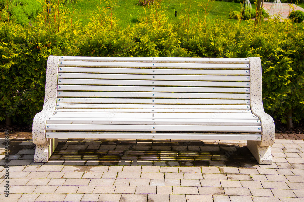 Large concrete benches with wooden elements. Near the alley in the park. Summer in the yard. Summer day. Large concrete benches with wooden elements. Near the alley in the park. Summer in the yard. Summer day.