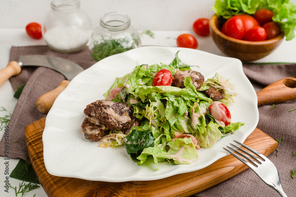 Salad with beef, lettuce, cherry tomatoes, and mayonnaise dressing. Cafe menu on a wooden background in warm colors with copy space. Salad with beef, lettuce, cherry tomatoes, and mayonnaise dressing. Cafe menu on a wooden background in warm colors with copy space.