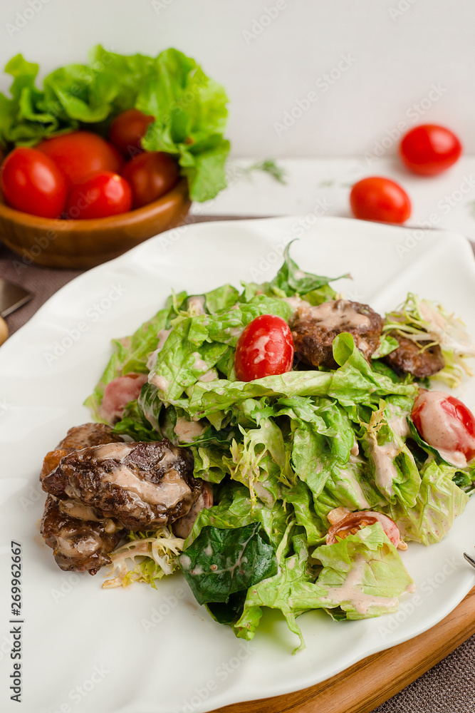 Salad with beef, lettuce, cherry tomatoes, and mayonnaise dressing. Cafe menu on a wooden background in warm colors with copy space. Salad with beef, lettuce, cherry tomatoes, and mayonnaise dressing. Cafe menu on a wooden background in warm colors with copy space.