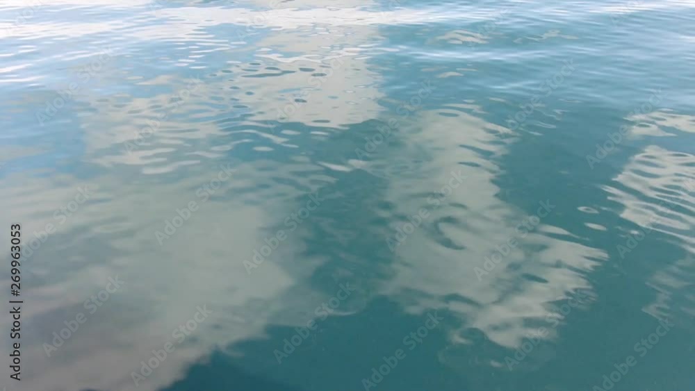 Reflecting surface of turquoise clear water from a driving boat. Tilt up, wide angle Reflecting surface of turquoise clear water from a driving boat. Tilt up, wide angle