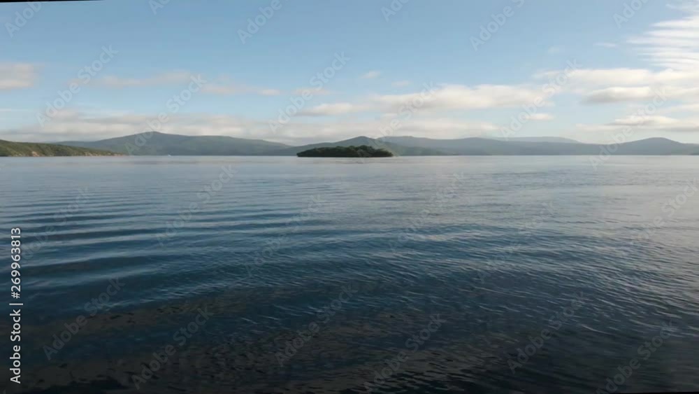 View from a boat on the Malborough Sound. Driving towards a lone island. Near Picton, New Zealand. Wide Angle, dolly
